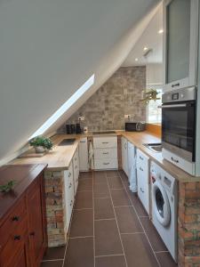 a kitchen with a staircase with a washer and dryer at Tündérkert Tündérfészek Vendégház in Sződliget +20 photos