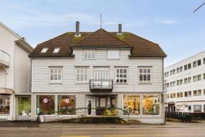 a large white house with a balcony on a street at Central Stay Odda in Odda