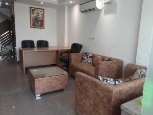 a living room with two couches and a table and chairs at Hotel O Daffodils in Gurgaon