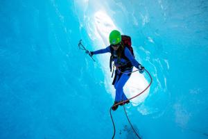 a person in the water with a backpack and a dolphin at Central Stay Odda in Odda