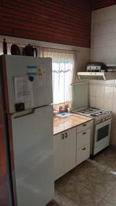 a kitchen with a white refrigerator and a stove at Casa Paganelli Germano in Aristóbulo del Valle +10 photos