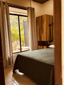 a bedroom with a bed and a large window at Casitas Amarillas in Uvita