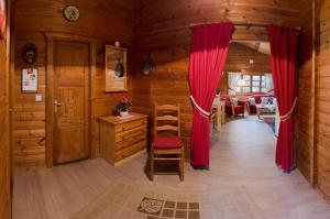 a room with red curtains in a wooden cabin at Bergblick Willingen in Neerdar