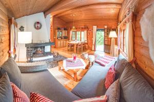a living room with a couch and a fireplace in a log cabin at Schwedenhaus Kaminzauber in Bömighausen