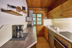 a kitchen with wooden cabinets and a counter top at Bergcottage in Neerdar