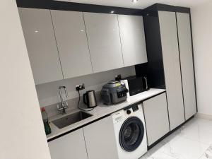 a kitchen with a washing machine and a microwave at Large Double Bed En-suite Room 20 mins from Heathrow in Burnham +3 photos