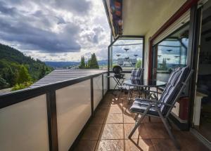 a balcony with chairs and a table on a roof at Chalet La Belle Willingen in Willingen +17 photos