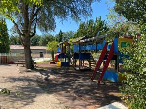 a playground in a park with a tree at Camping le Faucon d'or in Montricoux