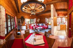 a dining room and living room in a log cabin at Hirsch Chalet in Bömighausen