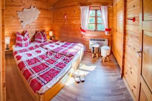 a bedroom with a large bed in a wooden room at Hirsch Chalet in Bömighausen