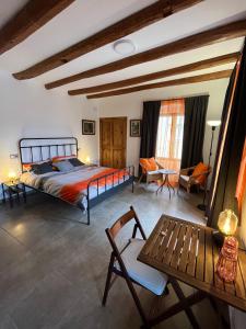 a bedroom with a bed and a table and chairs at La Casa Vella in Navarcles