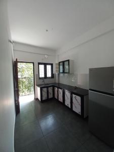 a large kitchen with a counter and a window at Enpathil Residency in Kollam