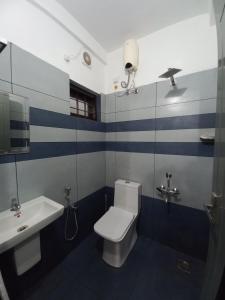 a bathroom with a white toilet and a sink at Enpathil Residency in Kollam