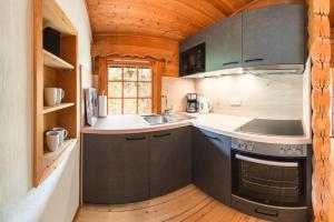 a kitchen with gray cabinets and a wooden floor at Chalet Papillon in Neerdar