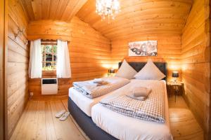 a bedroom with two beds in a log cabin at Chalet Papillon in Neerdar