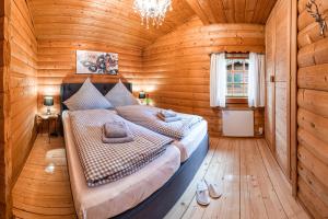 a bedroom with a bed in a wooden room at Chalet Papillon in Neerdar
