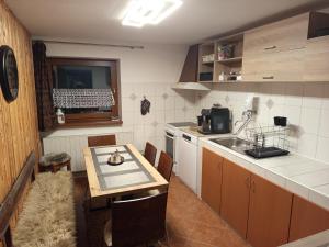 a kitchen with a table and a sink and a counter at Apartman Ustie in Trstená