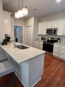 a kitchen with white cabinets and a white counter top at Endicott Cottage in Richmond