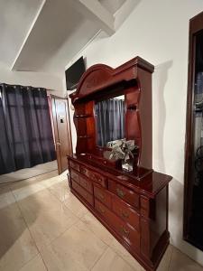 a wooden dresser with a mirror on top of it at El Hogar de Carmelita in Guanajuato