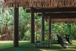a golf course in a resort with a straw roof at Le Bora Bora by Pearl Resorts in Bora Bora