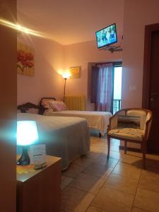 a hotel room with two beds and a flat screen tv at L'Antica Locanda da Gigino in Corniolo