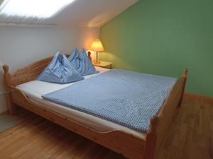 a bedroom with a wooden bed with blue pillows at Erlachmühle in Mondsee