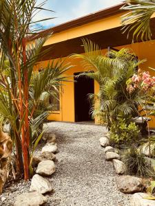 a garden with palm trees and rocks in front of a building at Casitas Amarillas in Uvita