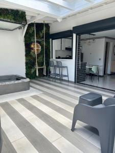 a living room with a patio with a table and chairs at Obonheur avec Jacuzzi in Le Gosier