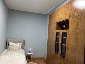 a bedroom with a bed and a large wooden cabinet at MONA app Apatin in Apatin +18 photos