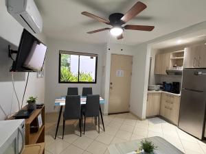 a living room with a dining room table and a ceiling fan at Casa Limonada Ground Condo in Coco