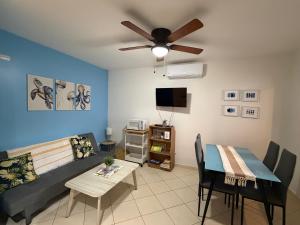 a living room with a couch and a ceiling fan at Casa Limonada Ground Condo in Coco
