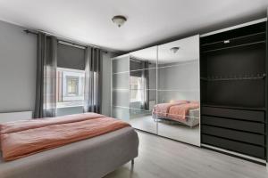 a bedroom with a bed and a mirror at Centrum apartment 2 in Ålesund