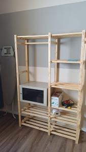 a wooden book shelf with a tv on it at Barreto Leme Studio 12 in Campinas