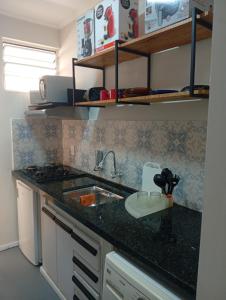 a kitchen with a sink and a counter top at Barreto Leme Studio 12 in Campinas