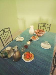 a blue table with plates of food on it at Maison La Baraka Merzouga in Merzouga
