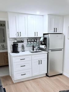 a kitchen with white cabinets and a white refrigerator at Newly Renovated 1BR Suite, Patio BBQ, Fire Pit in Simi Valley