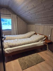 two beds in a room with a window at Harteigen cabin Lofoten retreat in Vestvågøya