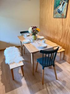 a wooden table with chairs and flowers on it at Cabañas Agua y Campo in Osorno