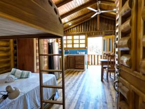 a bedroom with a bunk bed and a kitchen at Cabañas Samara Buenavista in Sámara
