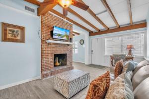 a living room with a brick fireplace and a tv at Island Gem B home in Anna Maria