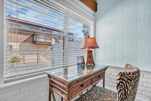 a glass desk in a room with a window at Island Gem B home in Anna Maria +29 photos