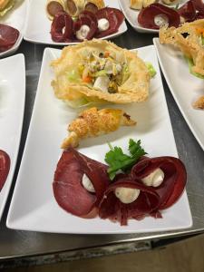 a white plate with different types of food on it at Hotel Cime d'Auta in Falcade +10 photos