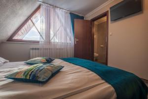 a bedroom with a bed with two pillows and a window at Ostrysz in Dzianisz