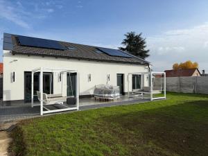 a white house with solar panels on the roof at WBR Apartlak in Villány