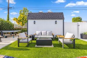 a backyard with chairs and a table and a house at 2BR 2BA Home Hot Tub, Firepit, Yard, BBQ, Parking in Simi Valley