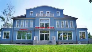 a blue building with a red sign on it at Penzion Vegas in Partizánske