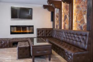 a leather couch in a living room with a fireplace at Ostrysz in Dzianisz