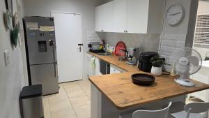 a kitchen with a refrigerator and a counter with a table at Hillcrest Cottage in Constantia