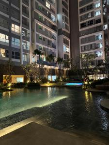 a swimming pool in a city at night with tall buildings at 221B Baker in Ấp Phú Thọ