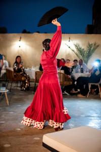 a woman in a red dress holding an umbrella at Free People Riad and Spa in Marrakesh